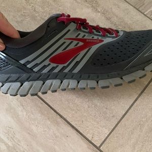 Gray and red running shoes by Brooks.